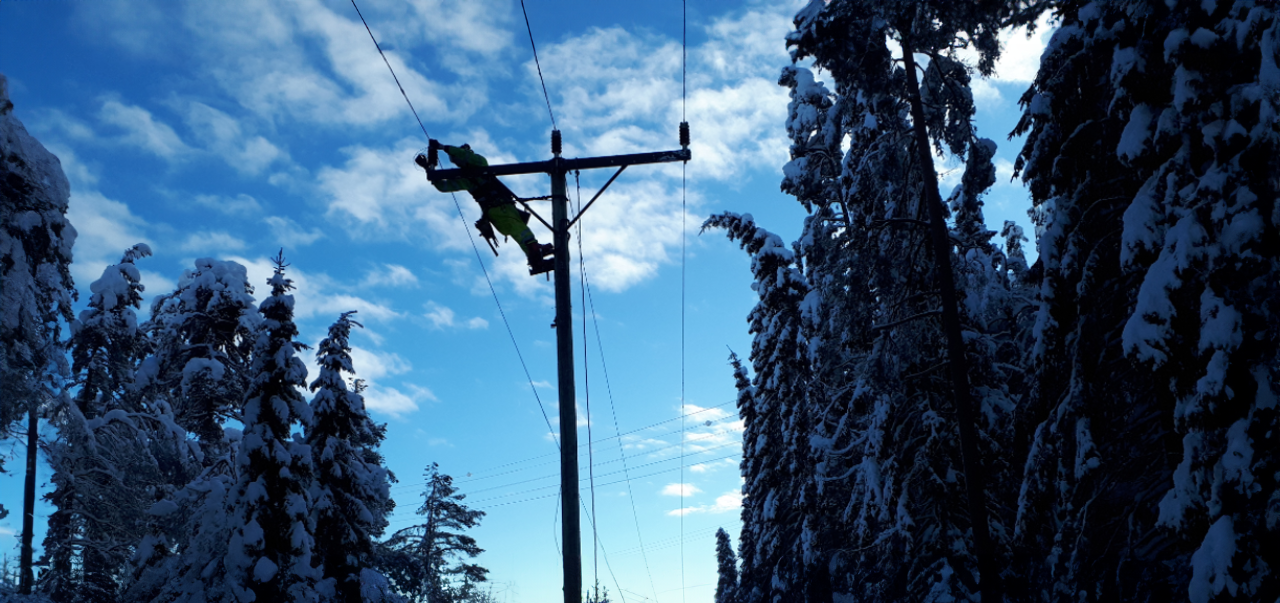 Montør jobber i mast, vinter.